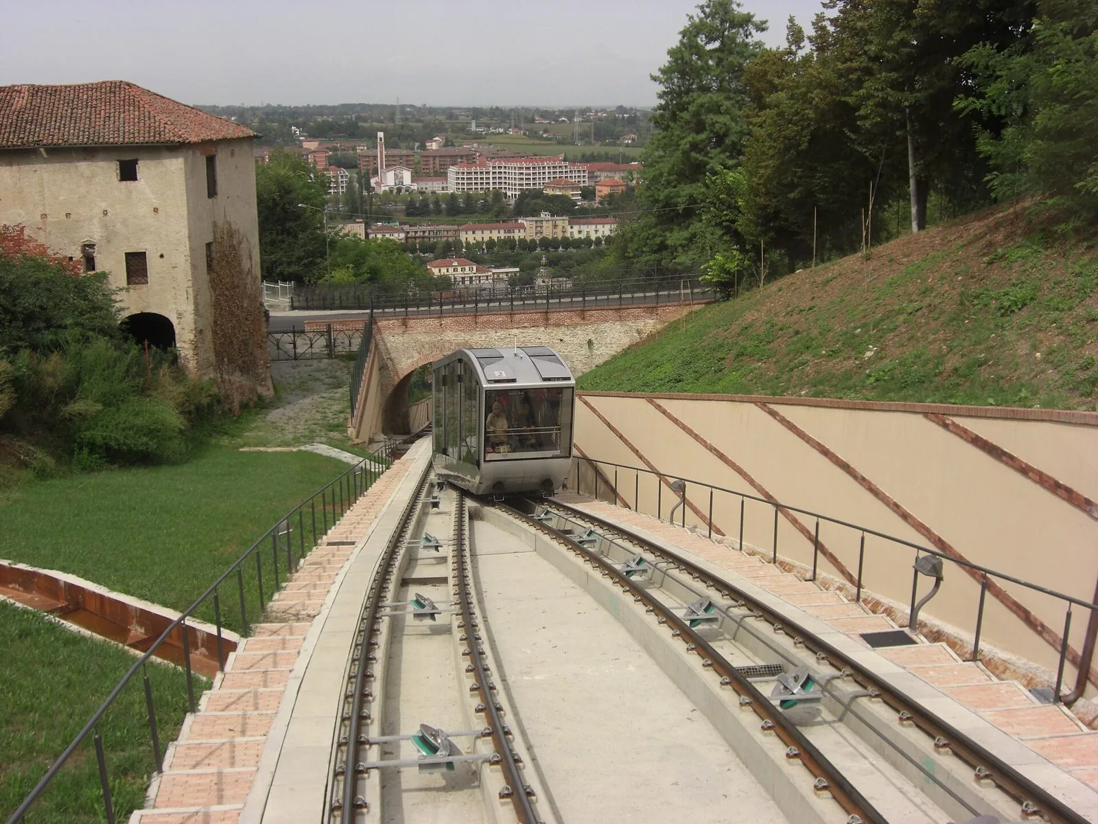 La vettura moderna della funicolare di Mondovì sul binario tra Breo e Piazza, con la città bassa sullo sfondo